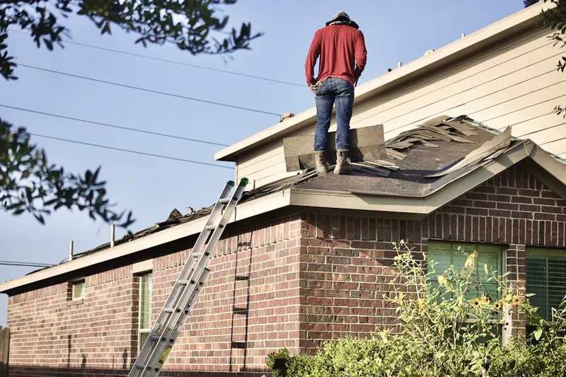 Professional roofer working on a residential roof in Helmetta
